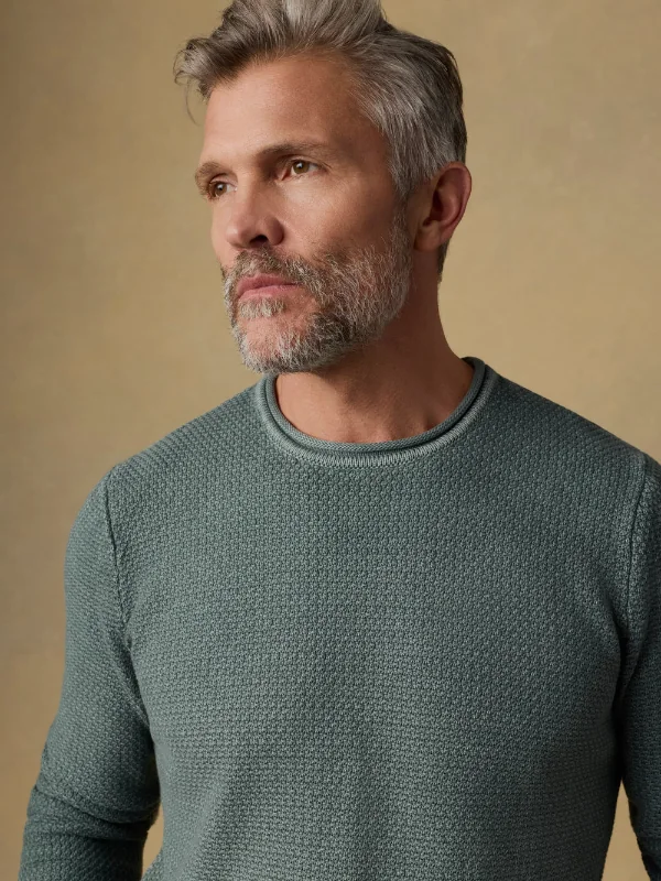 Man wearing a textured green knit top.